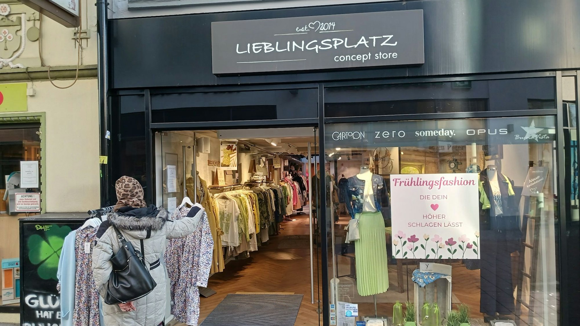 Eine Frau steht vor einem Modegeschäft.