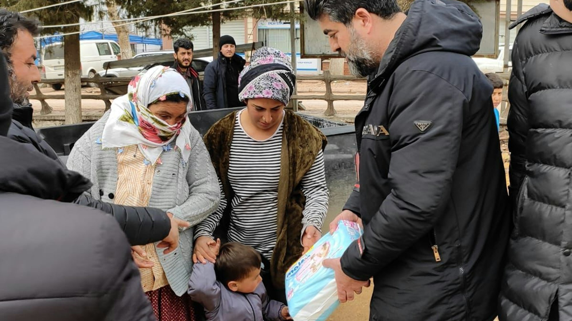 Erkan Karahan übergibt Windeln an zwei Frauen und ein Kind.