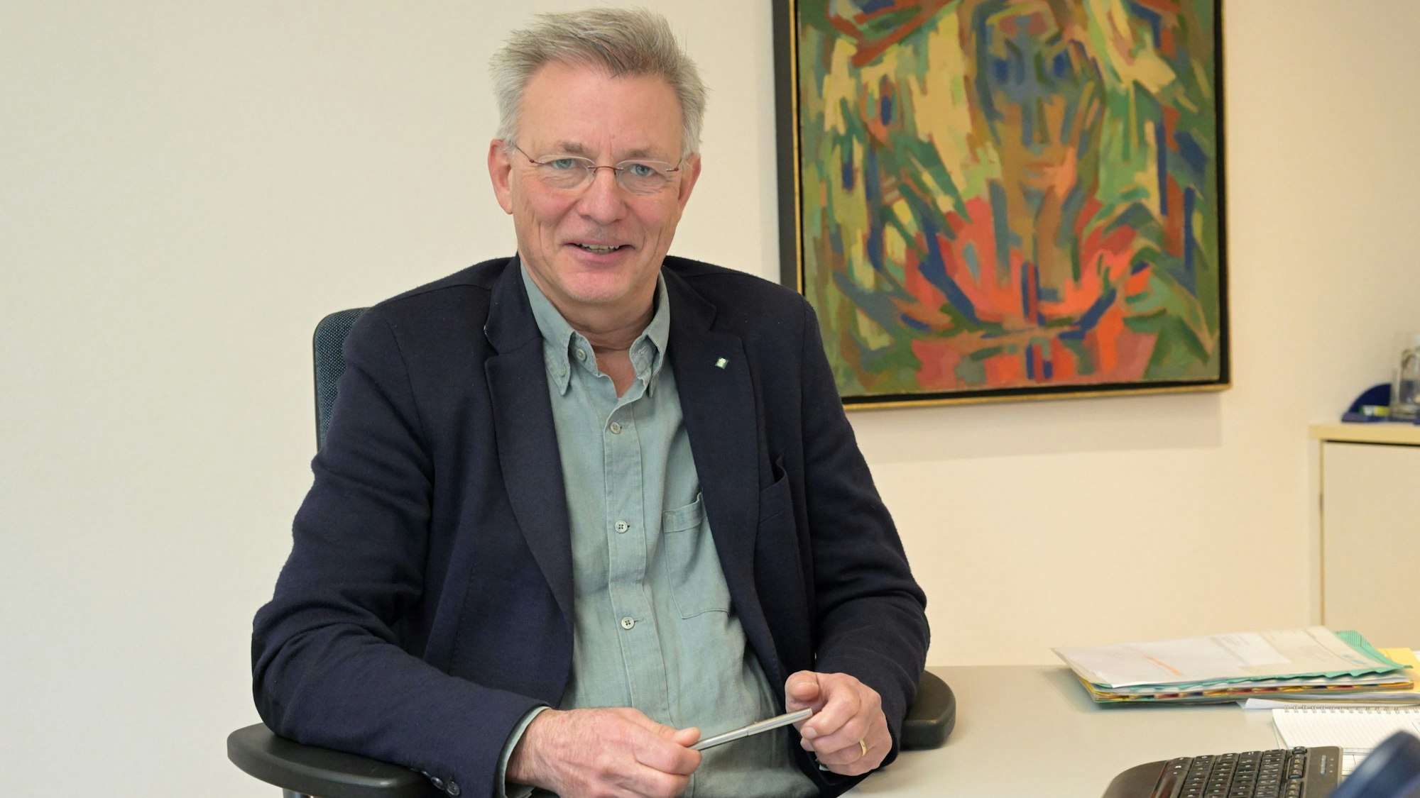 Dettlef Rockenberg sitzt an einem Schreibtsch.