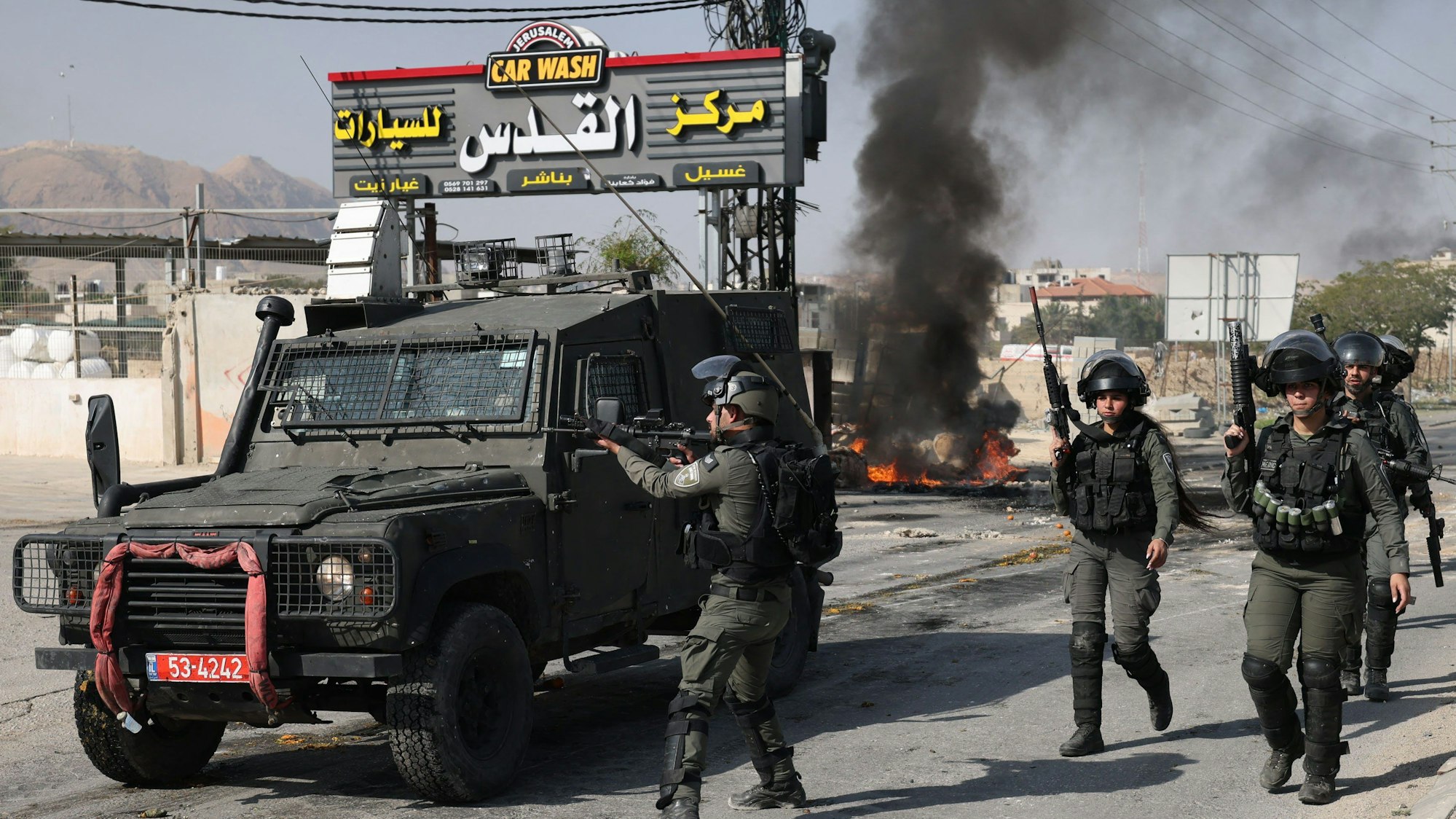 Isrealische Sicherheitskräfte patroullieren eine Straße.
