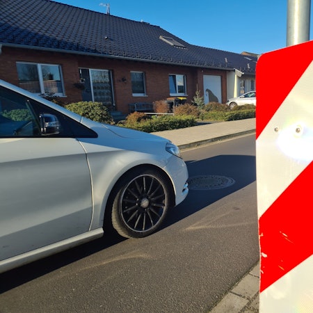 Ein weißes Auto fährt auf der Oleanderstraße.