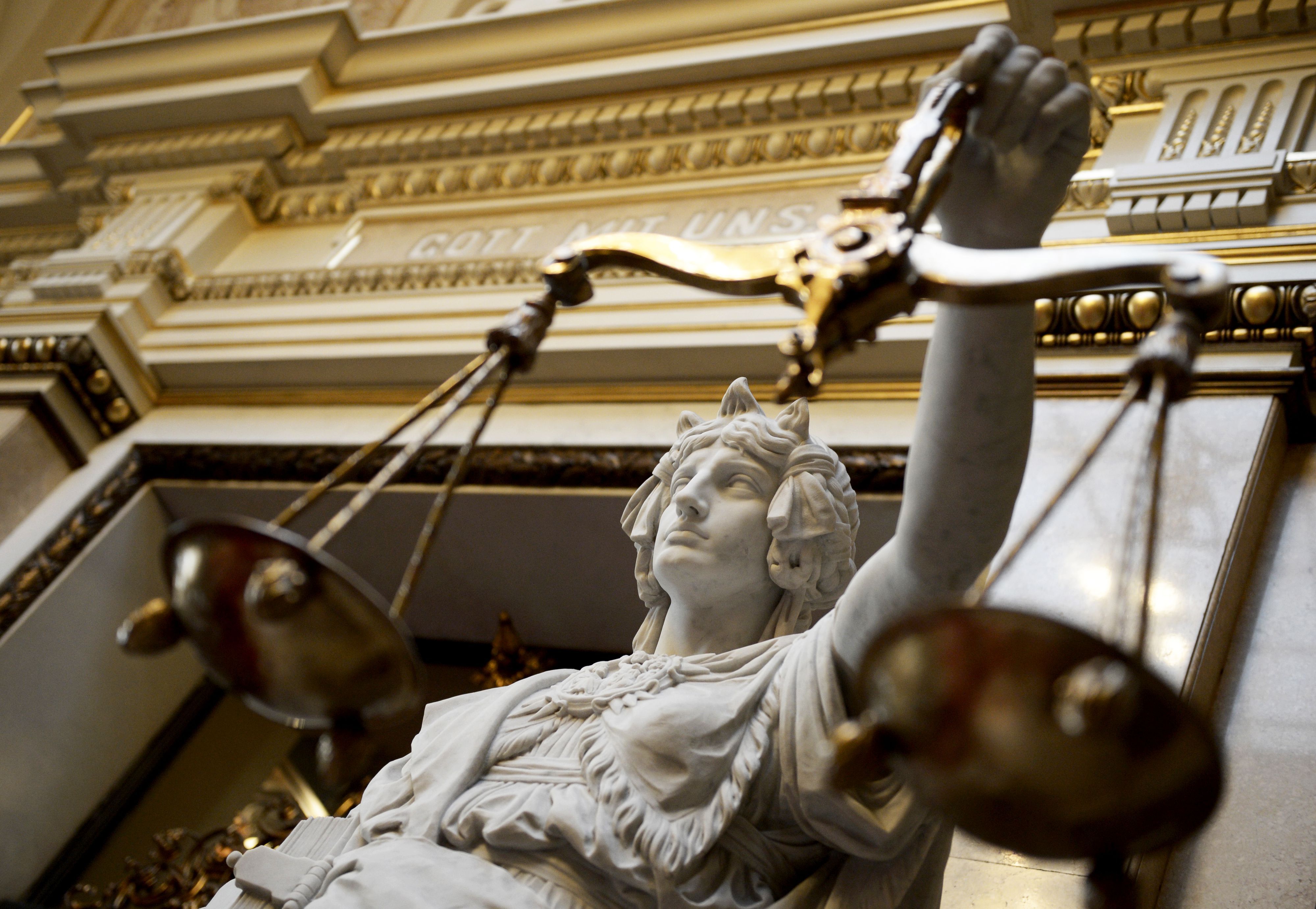 Eine Justitia vor einem Gerichtsgebäude