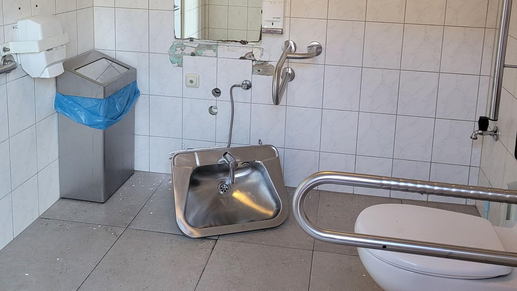 Das Waschbecken wurde mit roher Gewalt von der Wand gerissen und liegt auf den Fliesen.