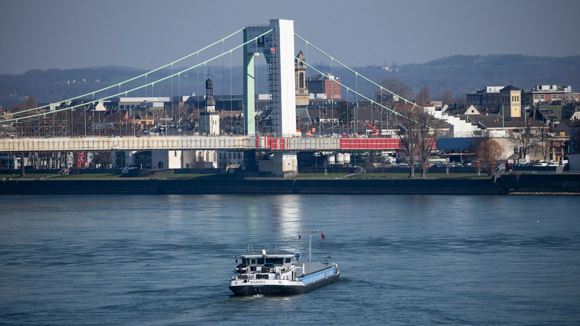 Blick auf die Mülheimer Brücke. Ein Frachtschiff fährt auf dem Rhein auf die Brücke zu.