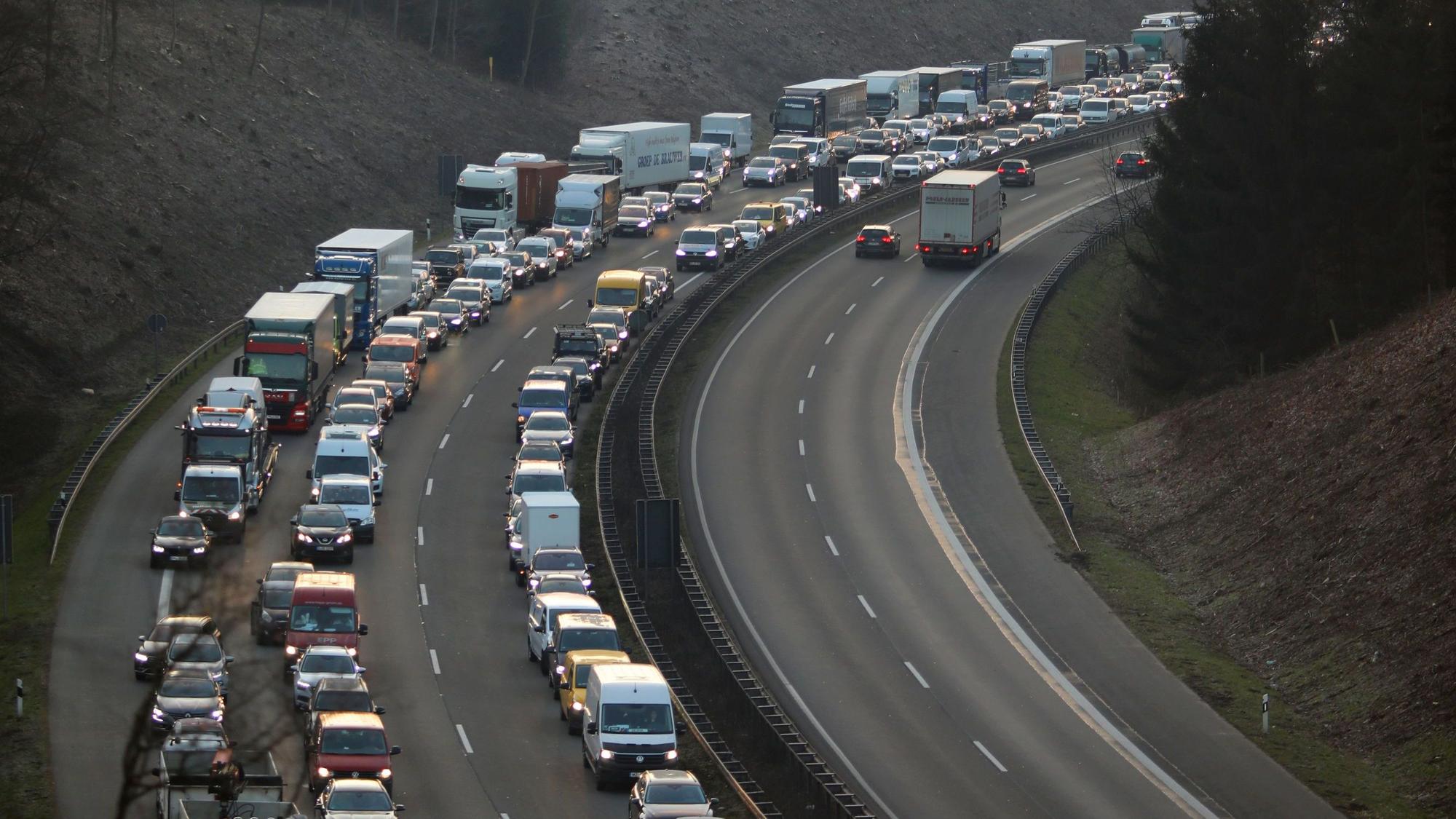 Autos und Lkw stehen im Stau auf der Autobahn, die Fahrerinnen und Fahrer haben eine Rettungsgasse gebildet.