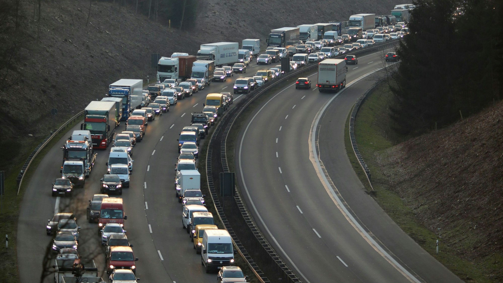 Autos und Lkw stehen im Stau auf der Autobahn, die Fahrerinnen und Fahrer haben eine Rettungsgasse gebildet.