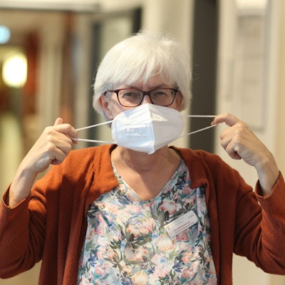 Eine Pflegerin legt die Maske ab.