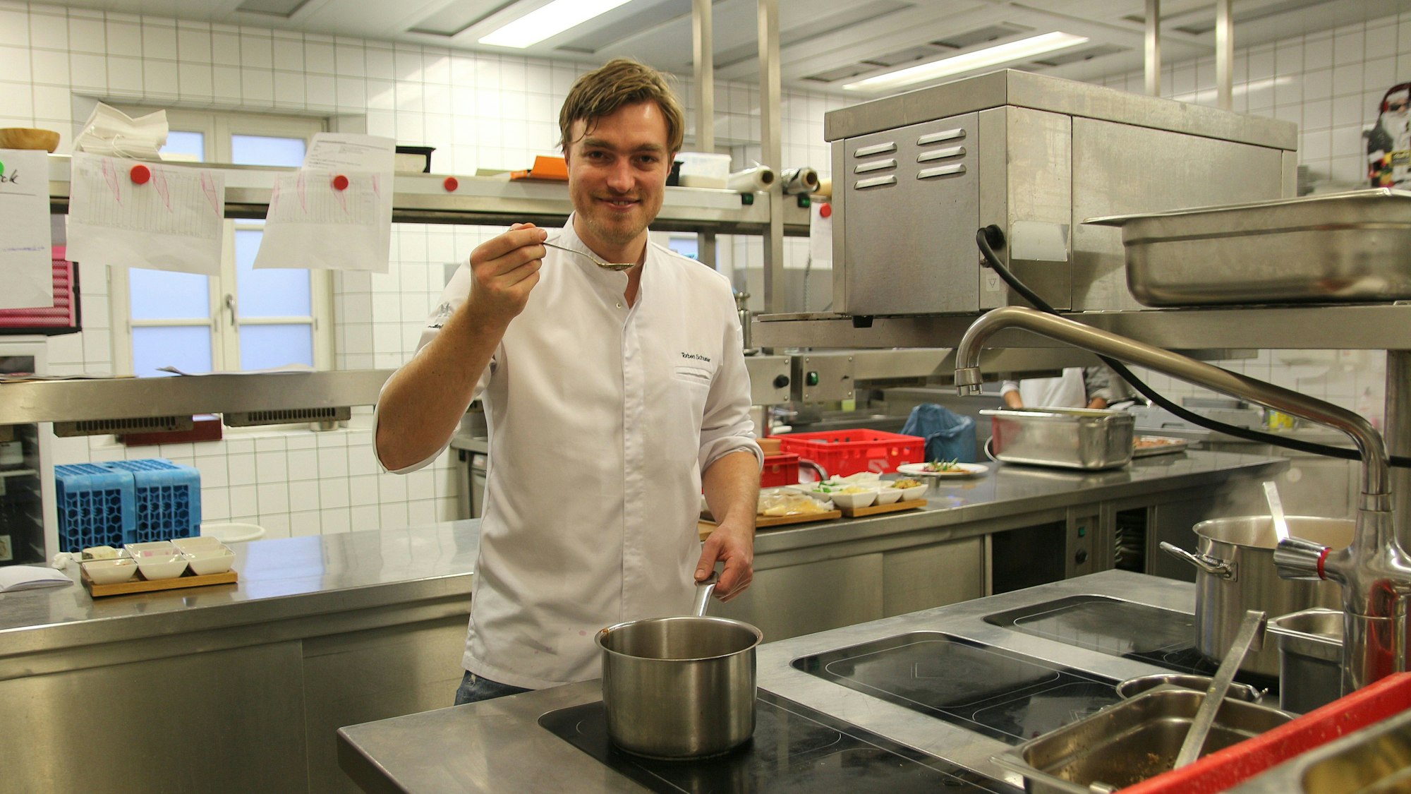 Das Foto zeigt Torben Schuster in der Küche des Restaurants Gut Lärchenhof in Pulheim.