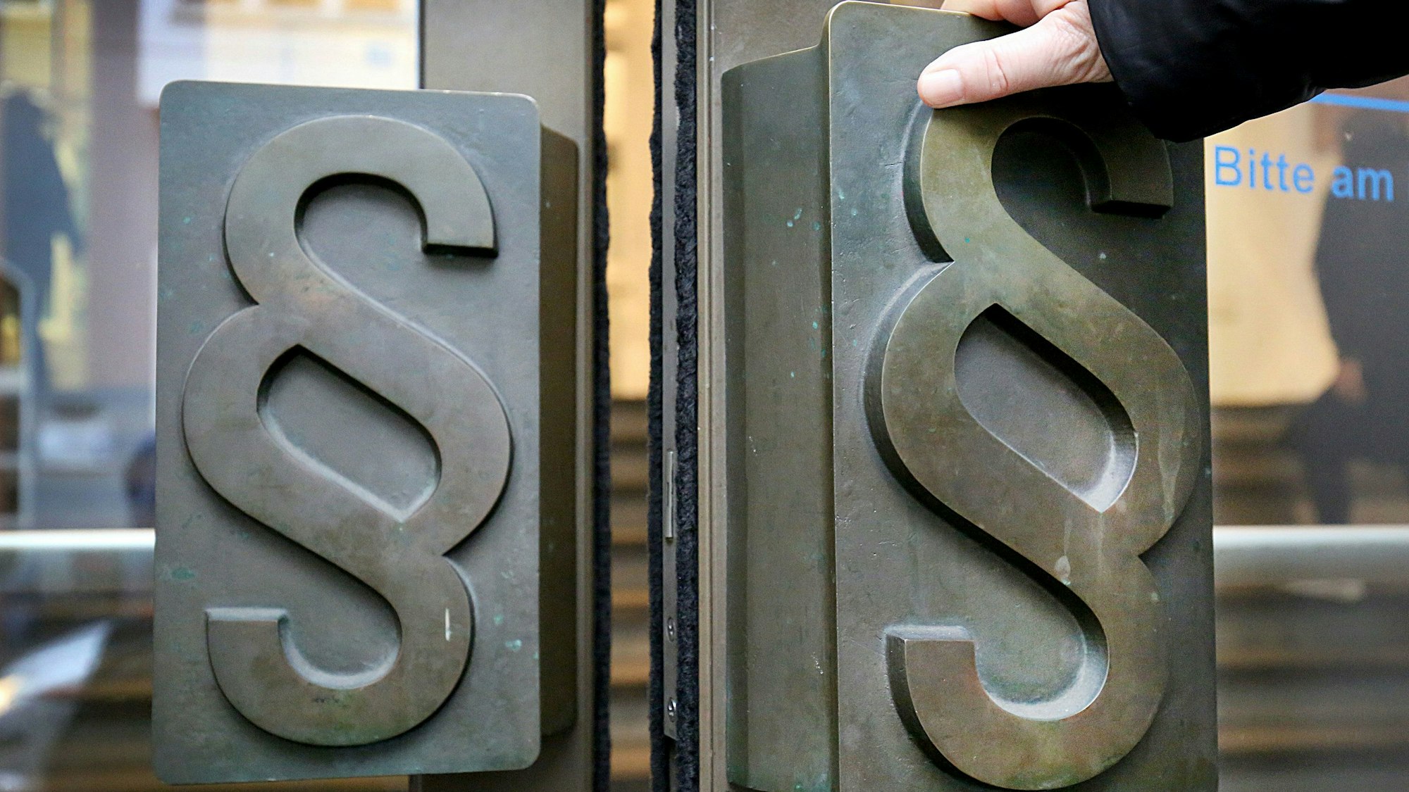 Paragrafen-Symbole sind an Türgriffen am Eingang zum Landgericht angebracht.