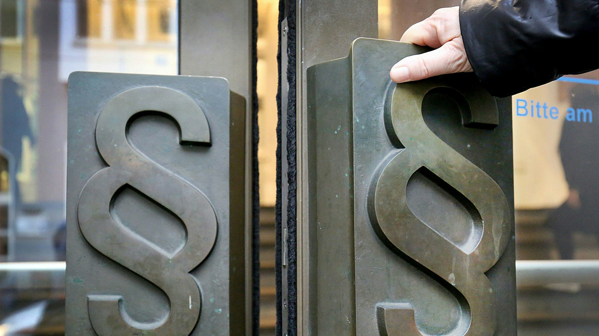 Paragrafen-Symbole sind an Türgriffen am Eingang zum Landgericht angebracht.