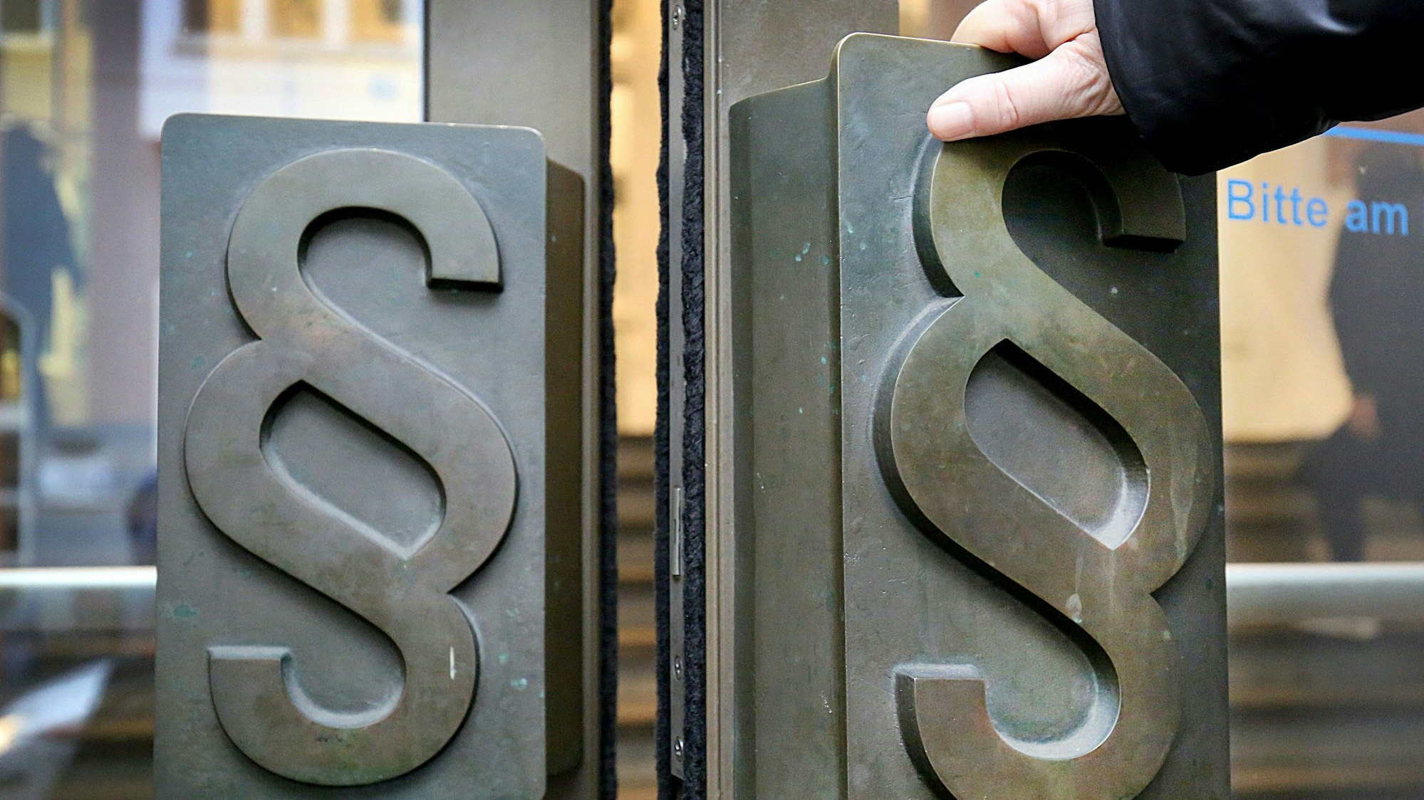 Paragrafen-Symbole sind an Türgriffen am Eingang zum Landgericht angebracht.