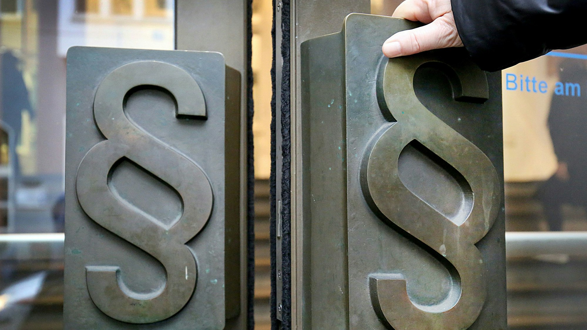 Paragrafen-Symbole sind an Türgriffen am Eingang zum Landgericht angebracht.