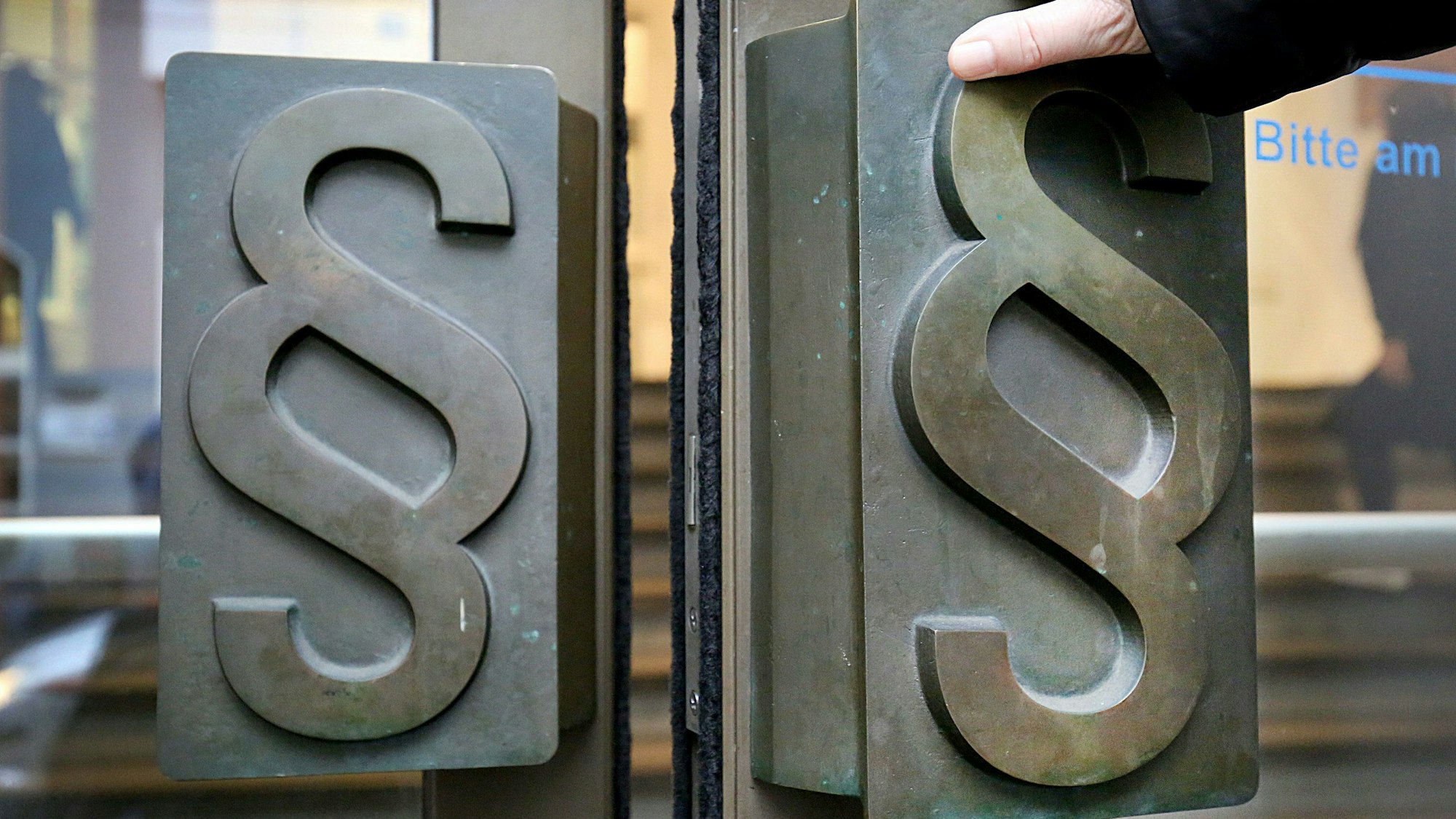 Paragrafen-Symbole sind an Türgriffen am Eingang zum Landgericht angebracht.