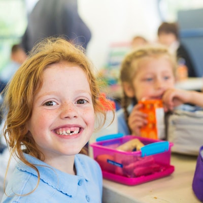 Ein Mädchen mit Zahnlücke lächelt.