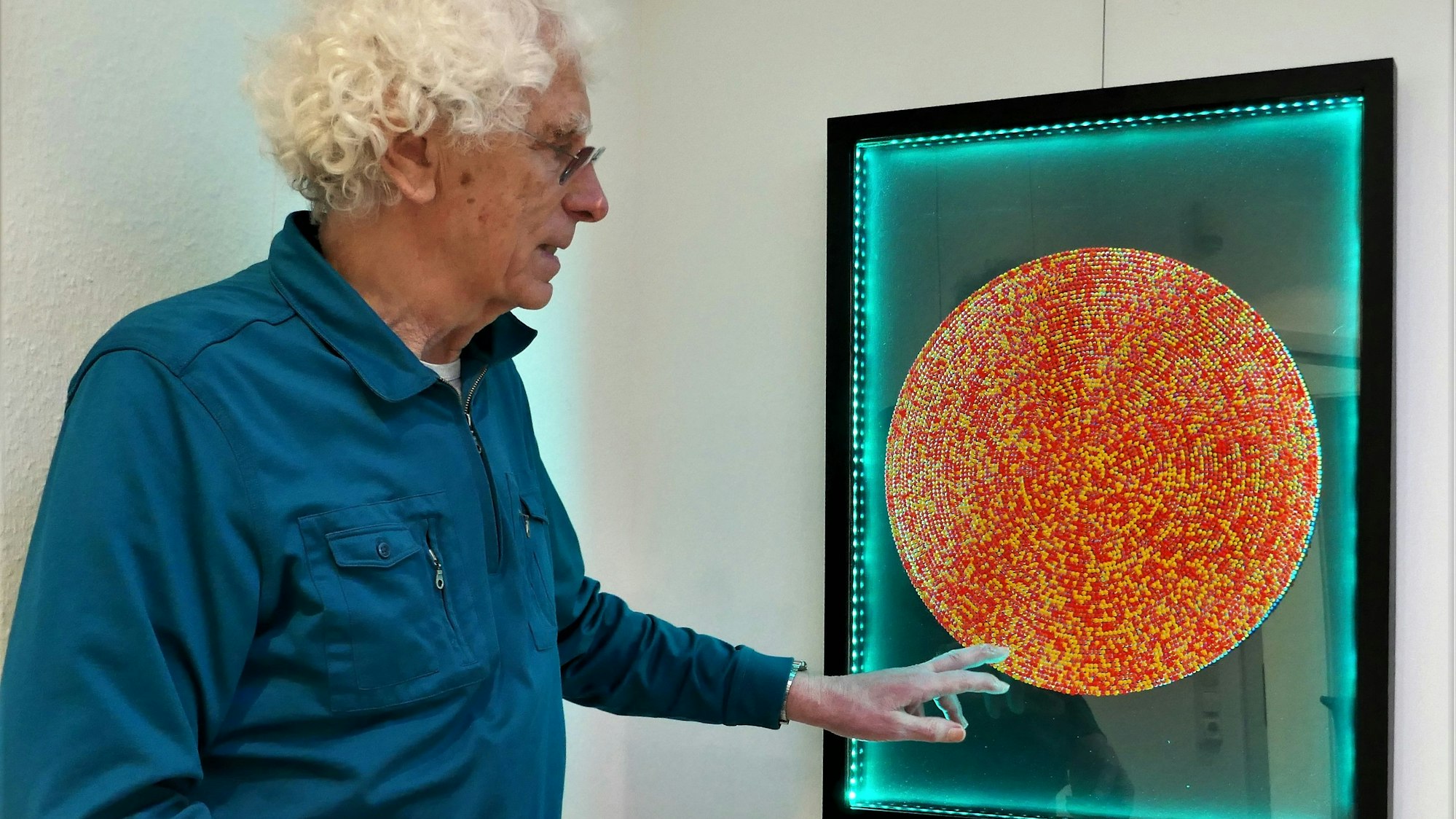 Knut Reinhardt hat einen farbwechselnden Bilderrahmen für seine kreisrunden Bilder aus Acryltropfen geschaffen.