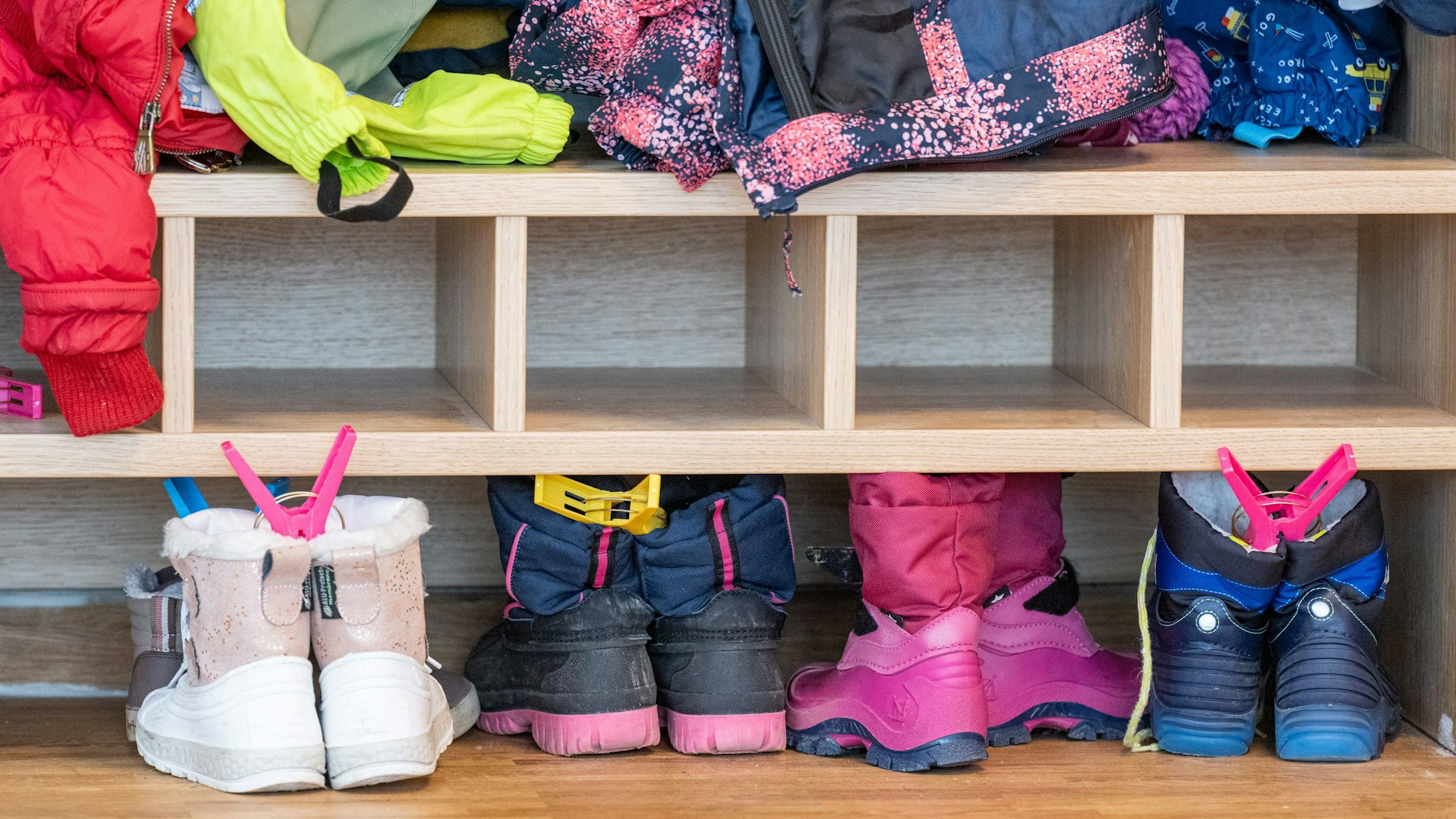 In einer Kita stehen Kinderschuhe vor einem Regal.