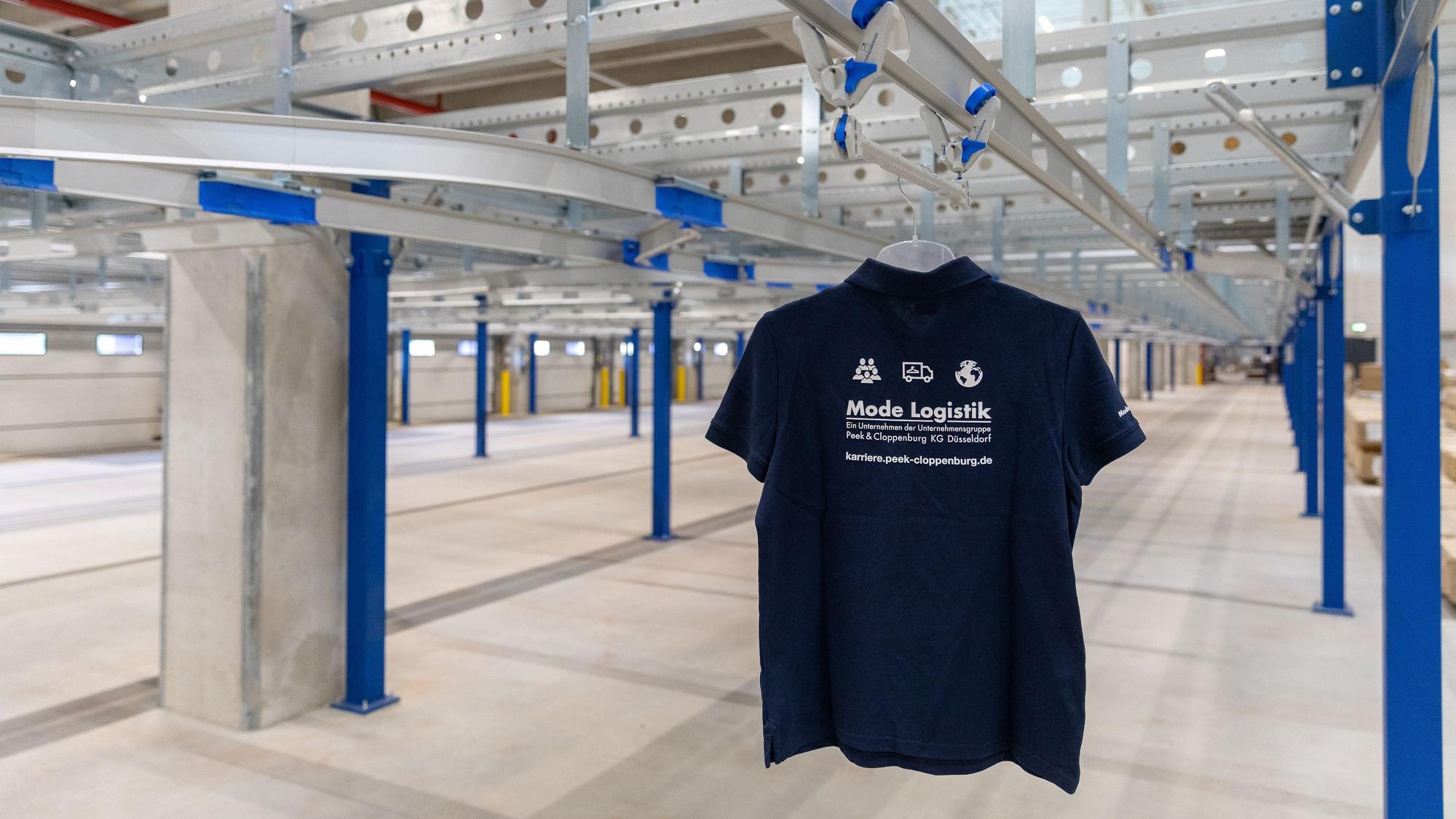 Auf dem Foto ist ein T-Shirt in dem neuen Logistikzentrum in Bedburg zu sehen. Es steht stellvertretend für die Bekleidungsstücke, die von dort aus versandt werden sollen.