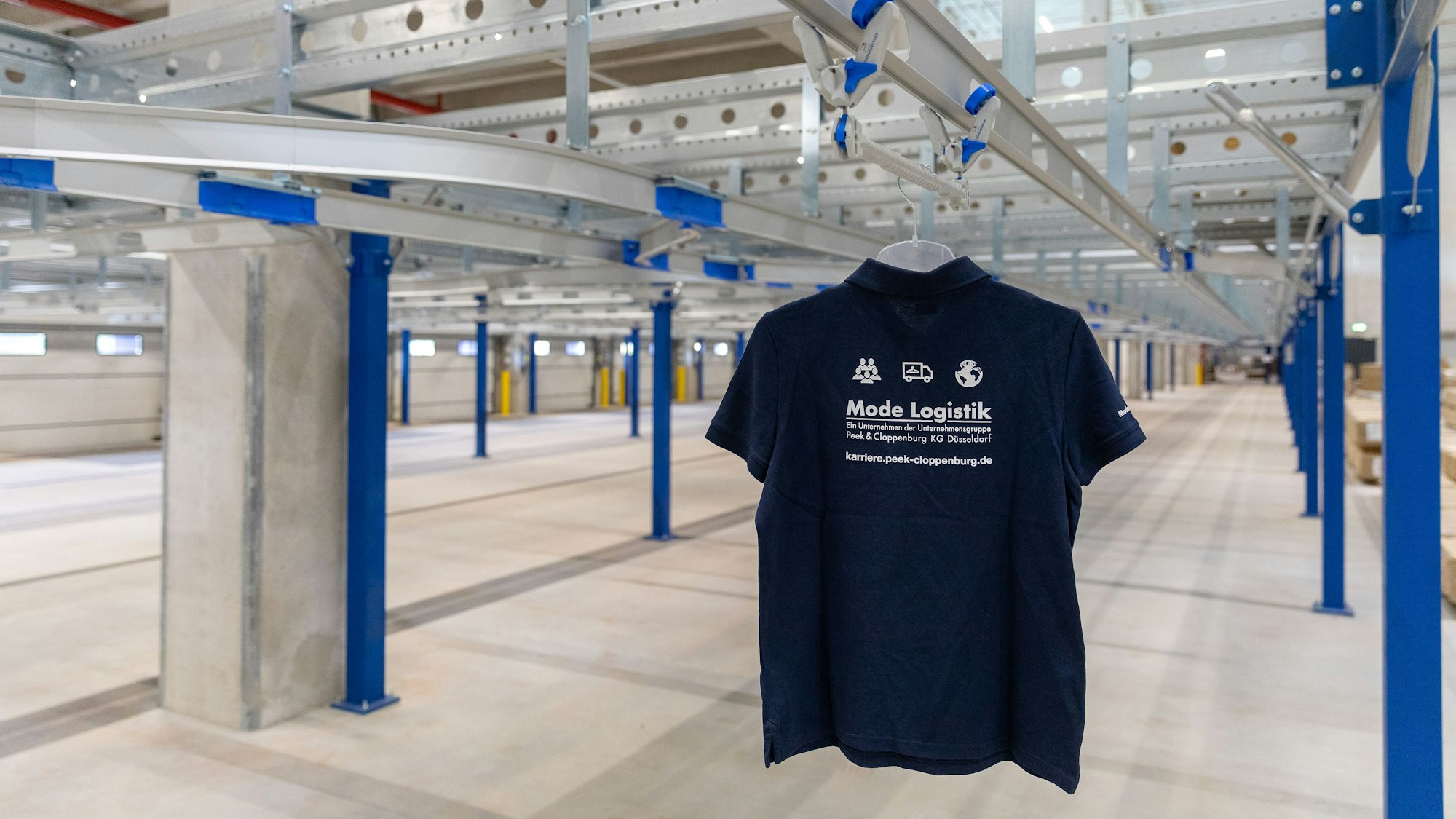 Auf dem Foto ist ein T-Shirt in dem neuen Logistikzentrum in Bedburg zu sehen. Es steht stellvertretend für die Bekleidungsstücke, die von dort aus versandt werden sollen.