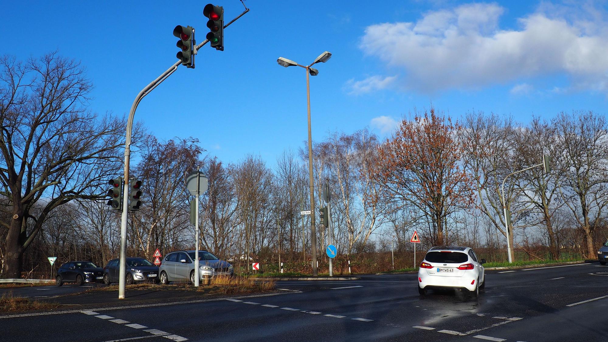 Das Foto zeigt eine Kreuzung. Mehrere Autos stehen vor einer Ampel, ein Wagen biegt nach links ab.