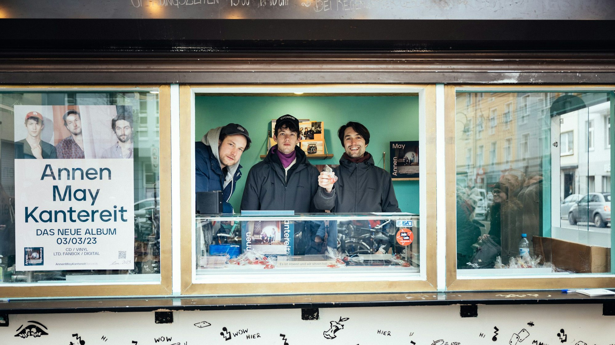 Severin Kantereit, Henning May und Christopher Annen stehen hinter der Theke ihres Büdchens auf der Zülpicher Straße in Sülz.