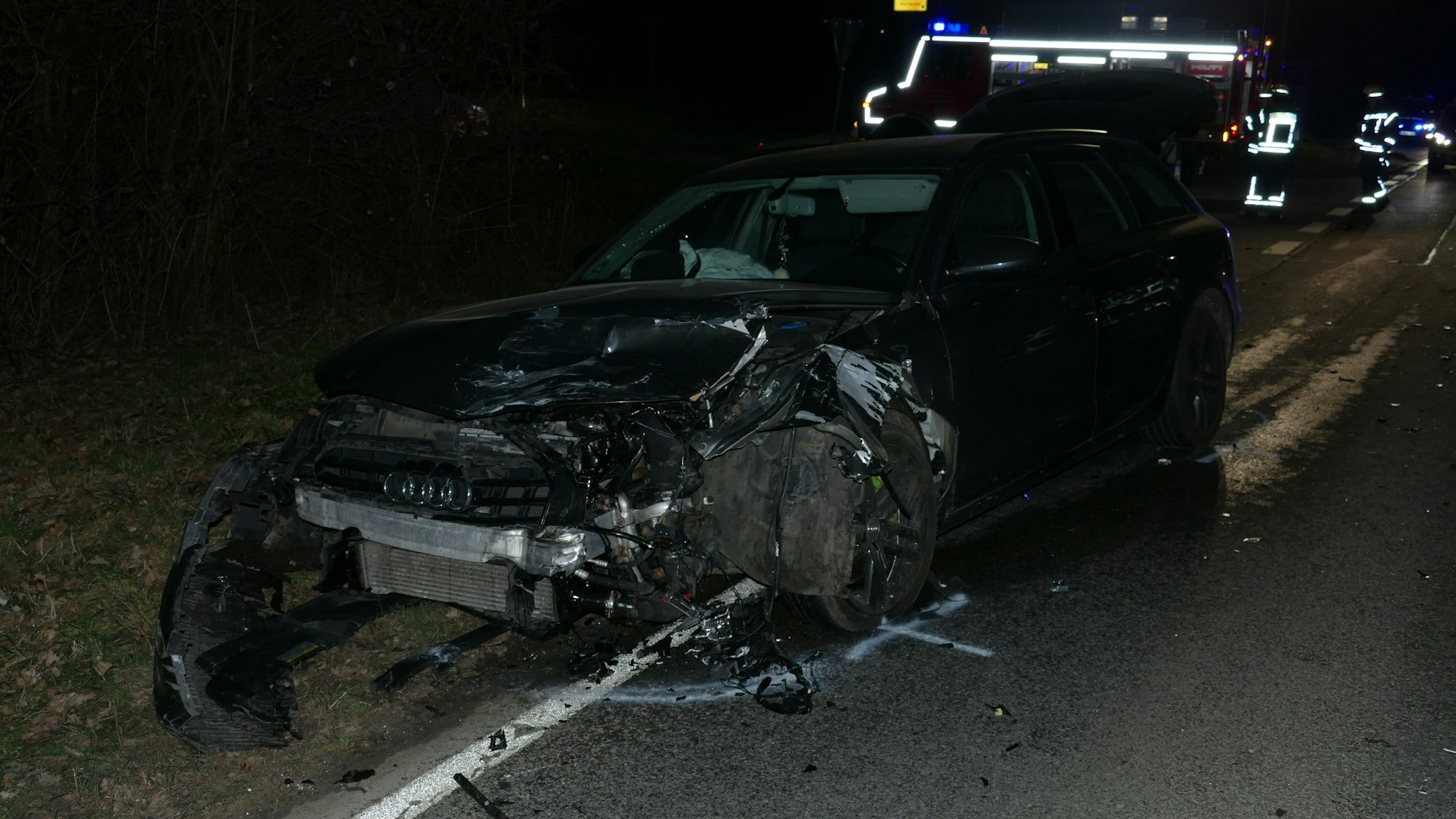 Ein Auto, das vom Unfall an der Vorderseite zerstört ist, steht am Straßenrand