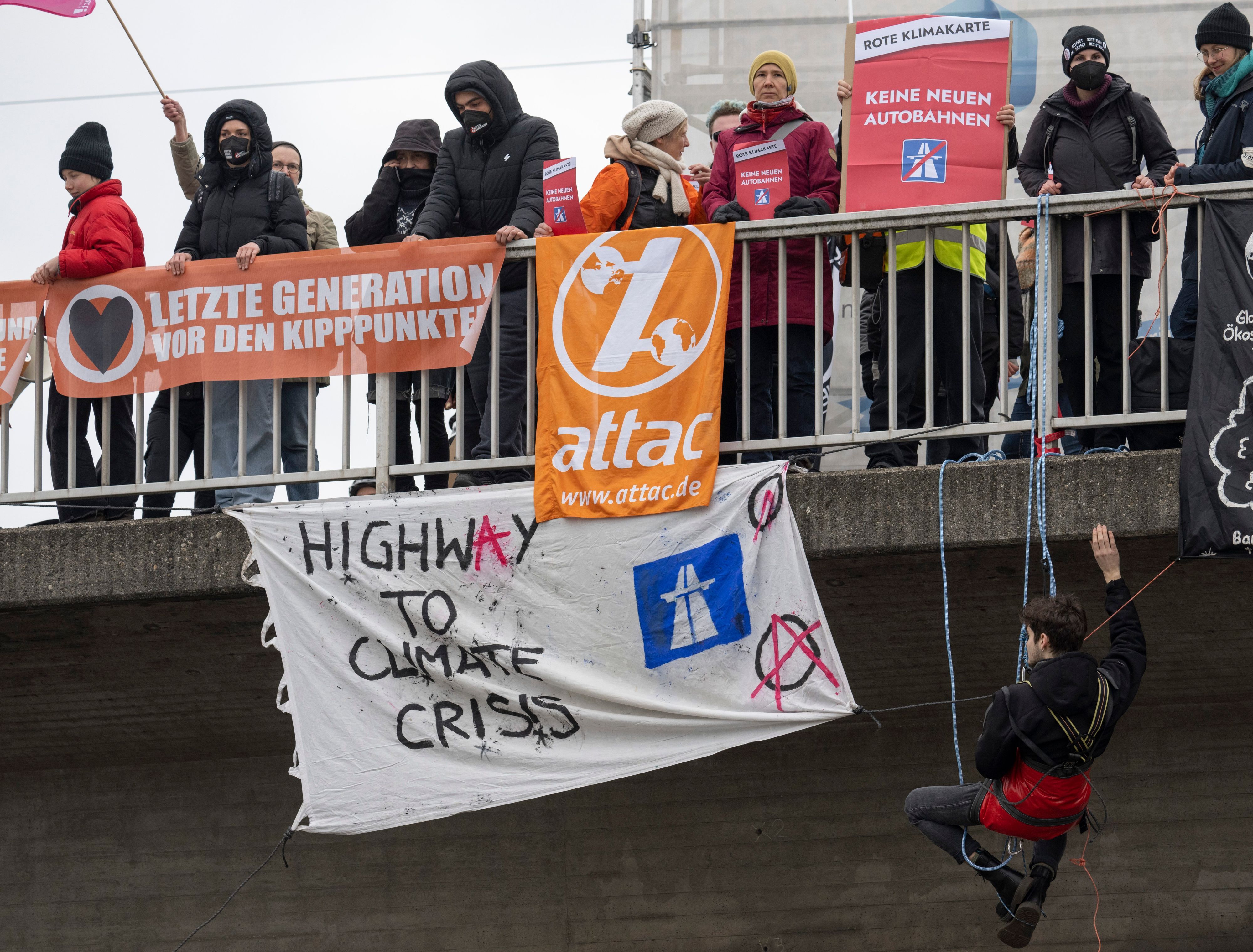 Aktivisten seilen sich von einer Brücke über der Autobahn 648 in Frankfurt ab.