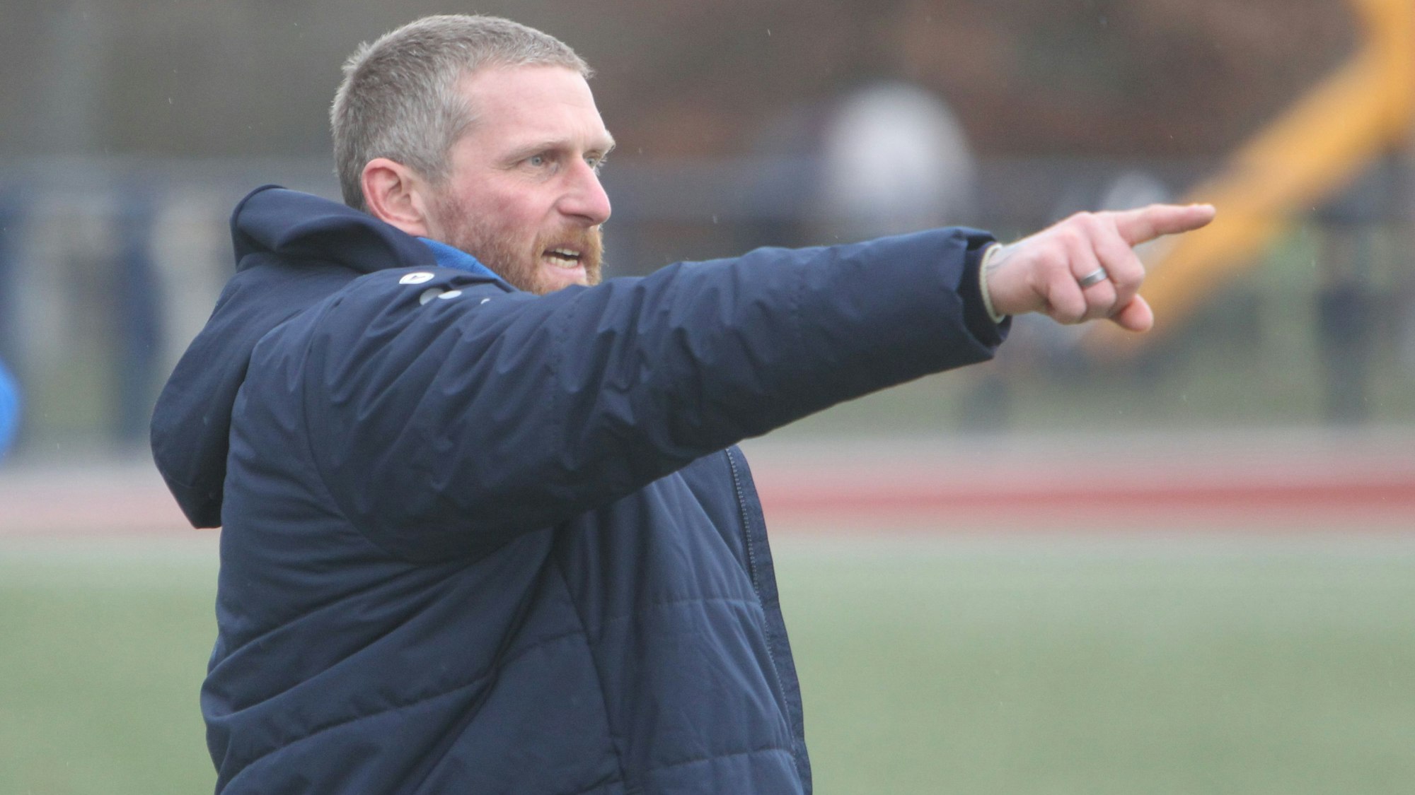 Trainer Didi Rombach vom SC Uckerath gibt mit ausgestrecktem Arm die Richtung vor.