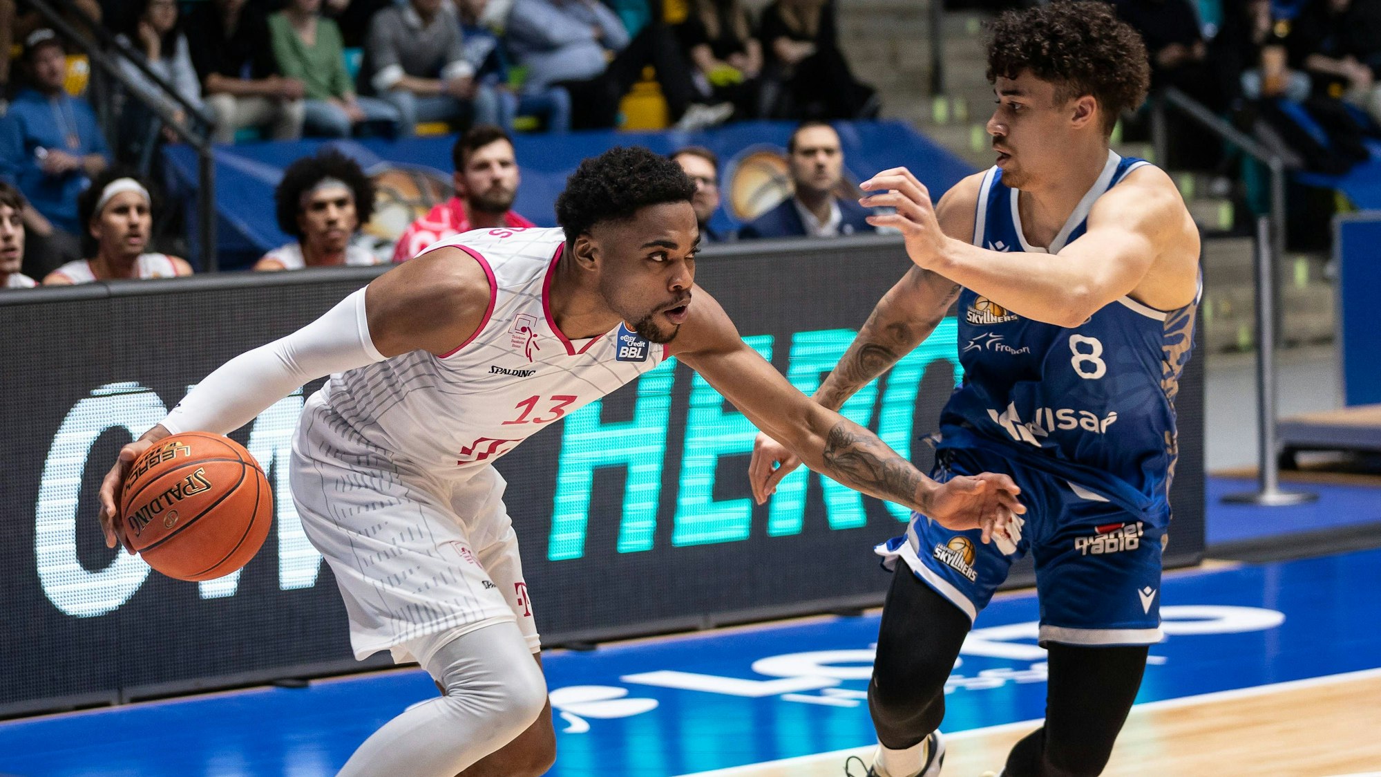 Javontae Hawkins von den Telekom Baskets und Joshua Obiesie von den Fraport Skyliners auf dem Platz.