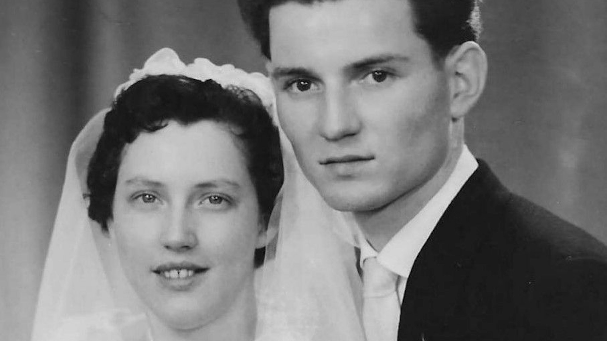 Man sieht das Brautpaar auf einer schwarz-weiß-Fotografie.