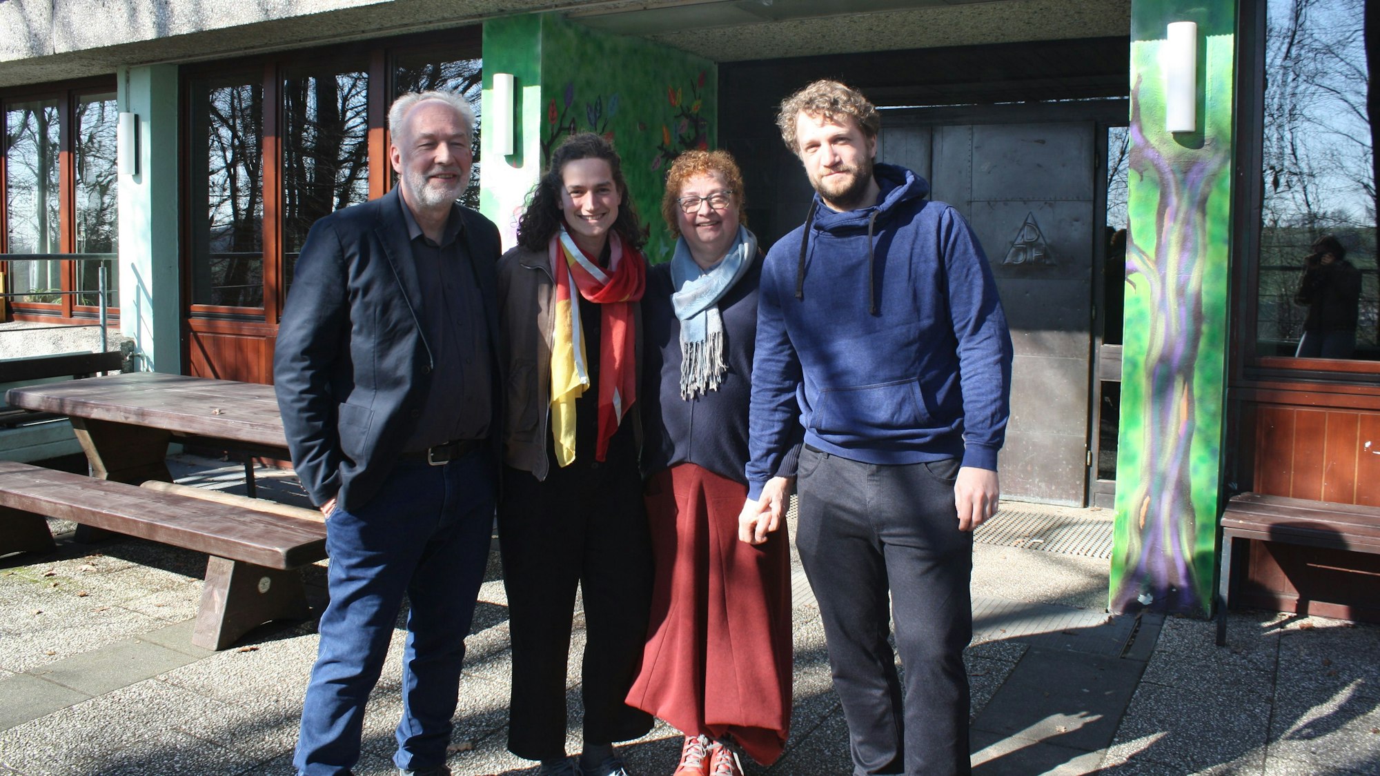 Die Familie steht vor dem Eingang eines Hauses und schaut in die Kamera.