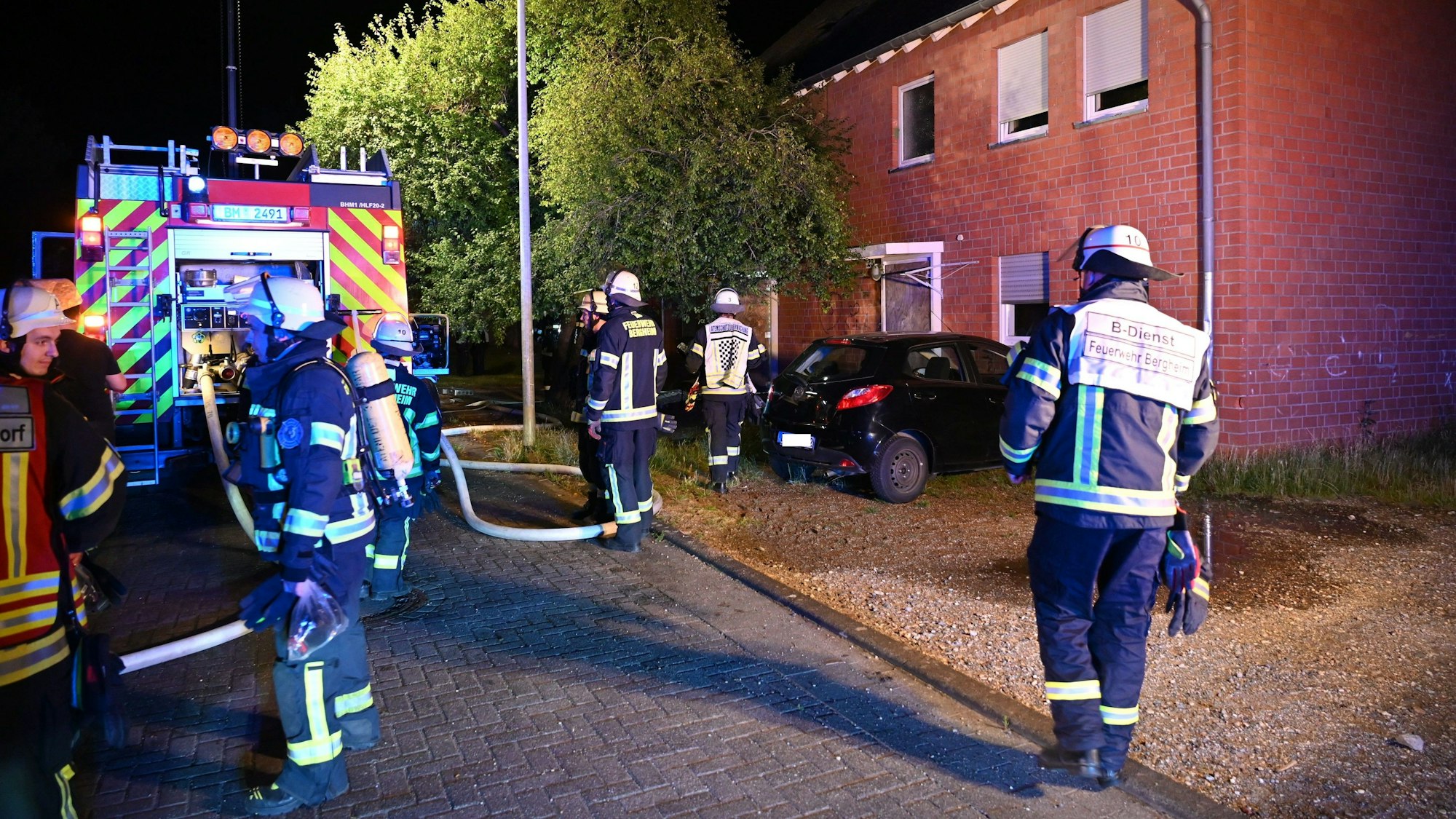 Auf dem Foto ist der Löscheinsatz der Feuerwehr zu sehen, nachdem im Treppenhaus eines Mehrfamilienhauses in Bergheim ein Feuer ausgebrochen worden war.