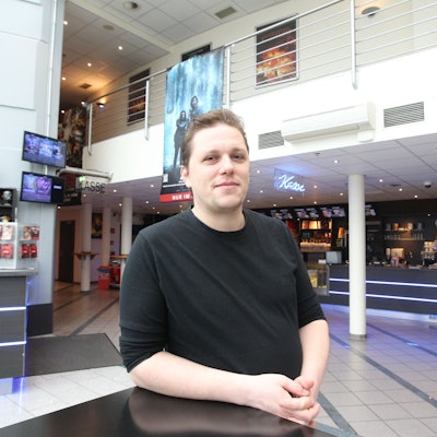 Ein Mann steht im Innenraum eines Kinos.