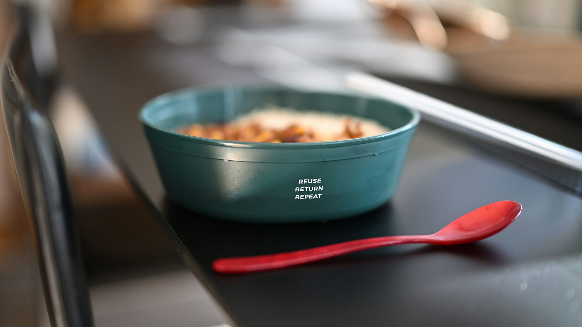 Eine Mehrwegschüssel steht mit Essen gefüllt auf einem Tisch.