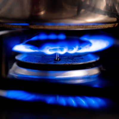 Eine Gasflamme brennt auf einem Küchenherd in einer Wohnung.