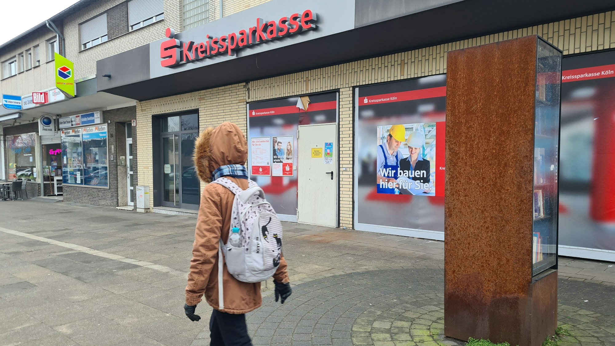 Eine Fußgängerin geht an der geschlossenen KSK-Filiale in Kaster vorbei.