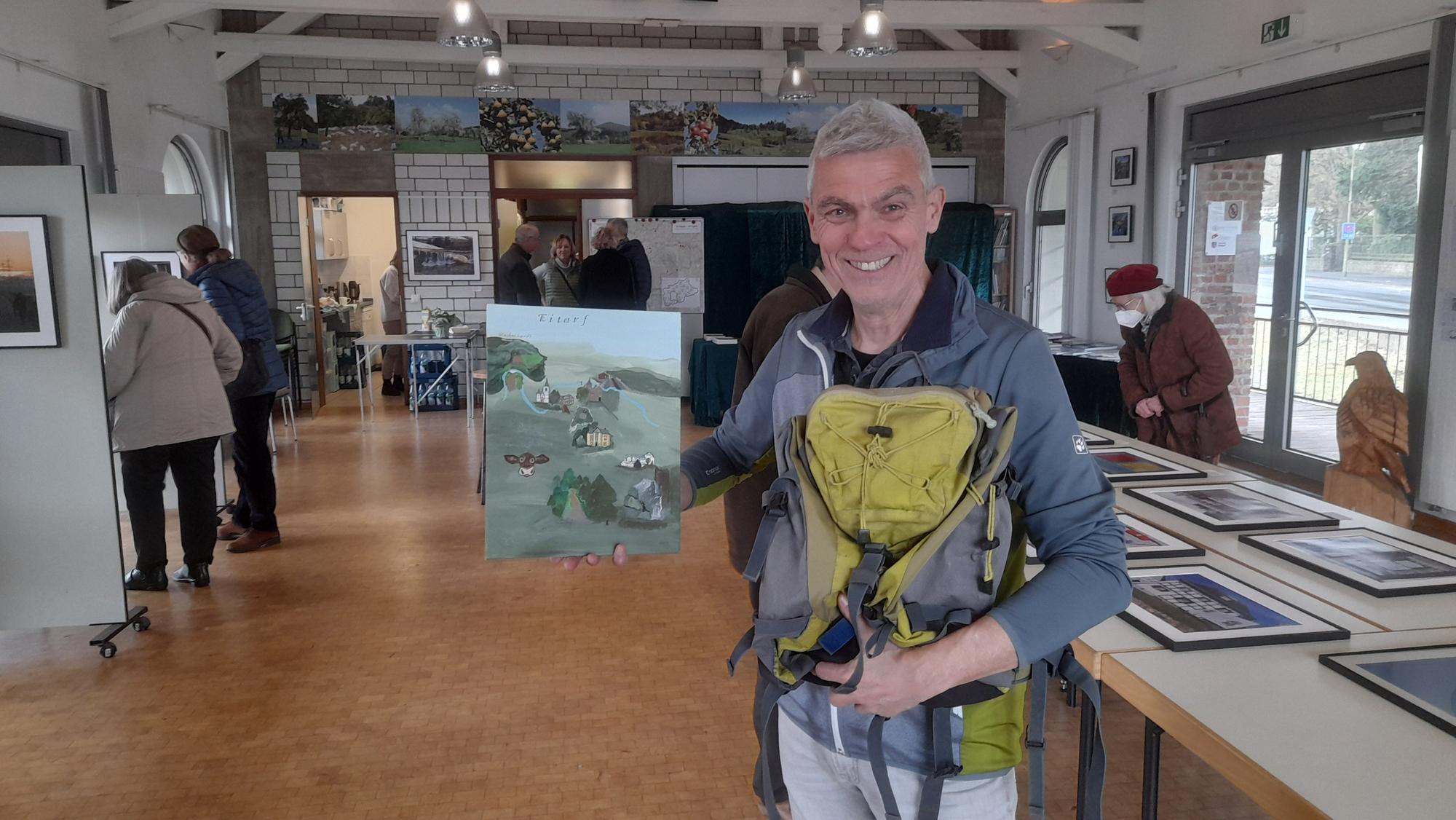Der Siegburger Klaus Strack hält ein Bild von seinen alternativen Wanderungen hoch.