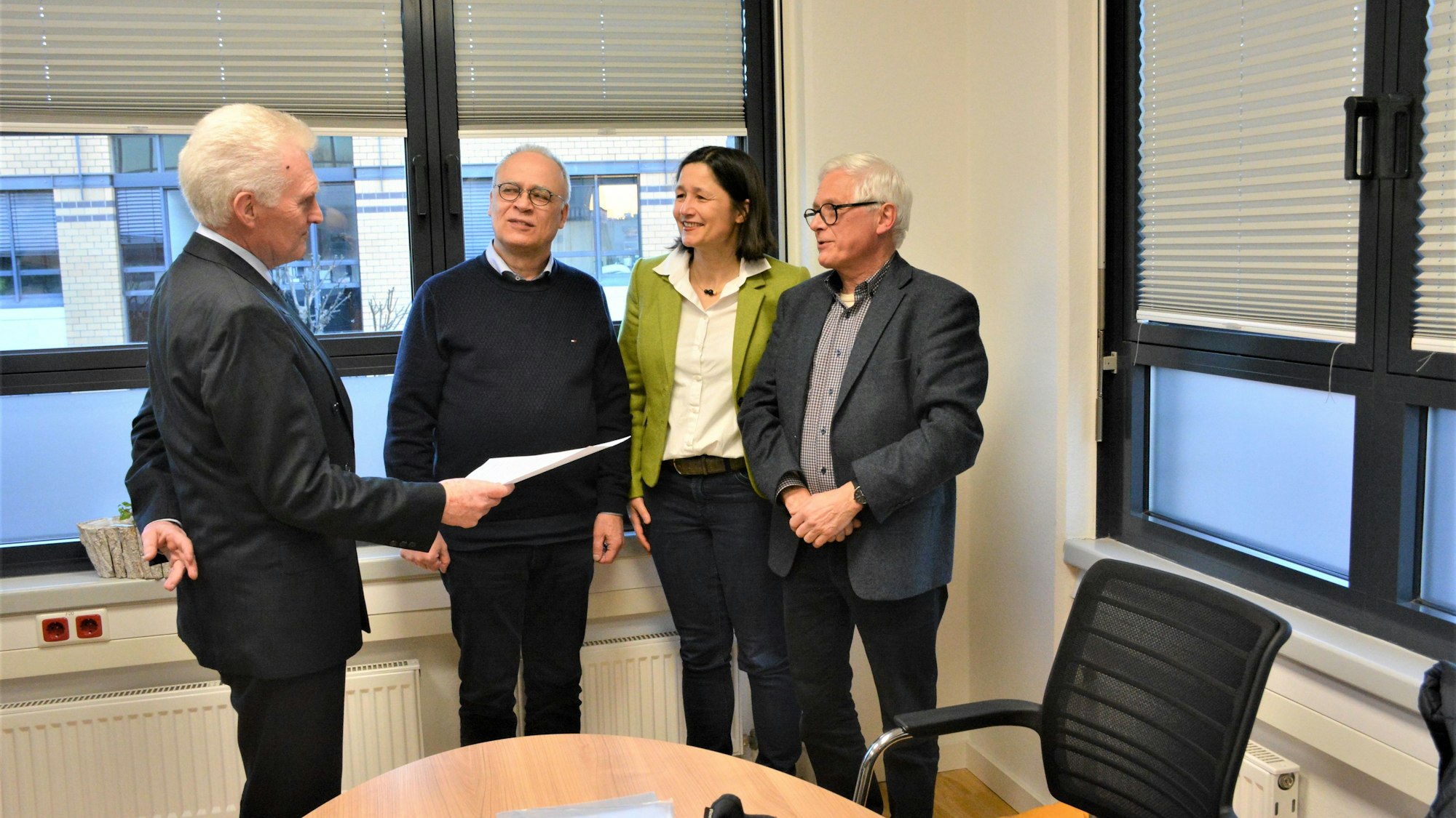 Manfred Giesen nimmt die Unterschriftenliste von Christoph Enders, Katja Kröll und Thomas Grothkopp entgegen (v.l.).
