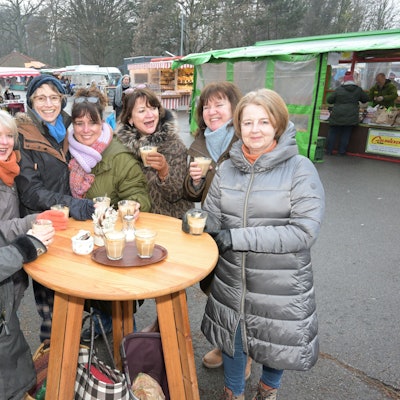Sieben Frauen stehen mit Kaffee um einen Stehtisch auf dem Markt in Bergisch Gladbach-Refrath.