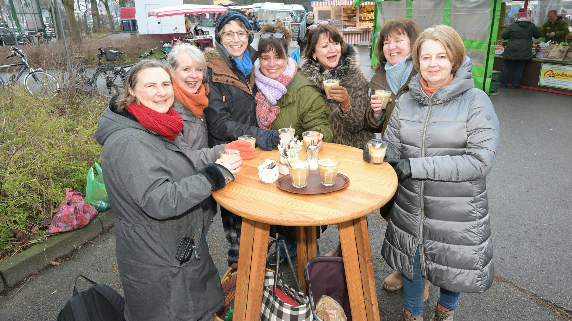 Sieben Frauen stehen mit Kaffee um einen Stehtisch auf dem Markt in Bergisch Gladbach-Refrath.