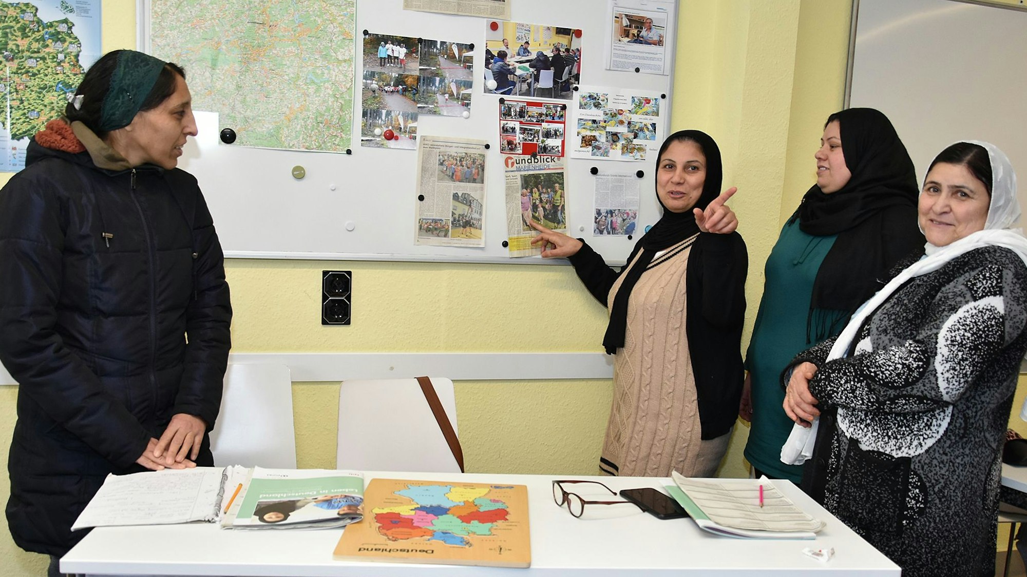 Frauen stehen an einer Tafel.