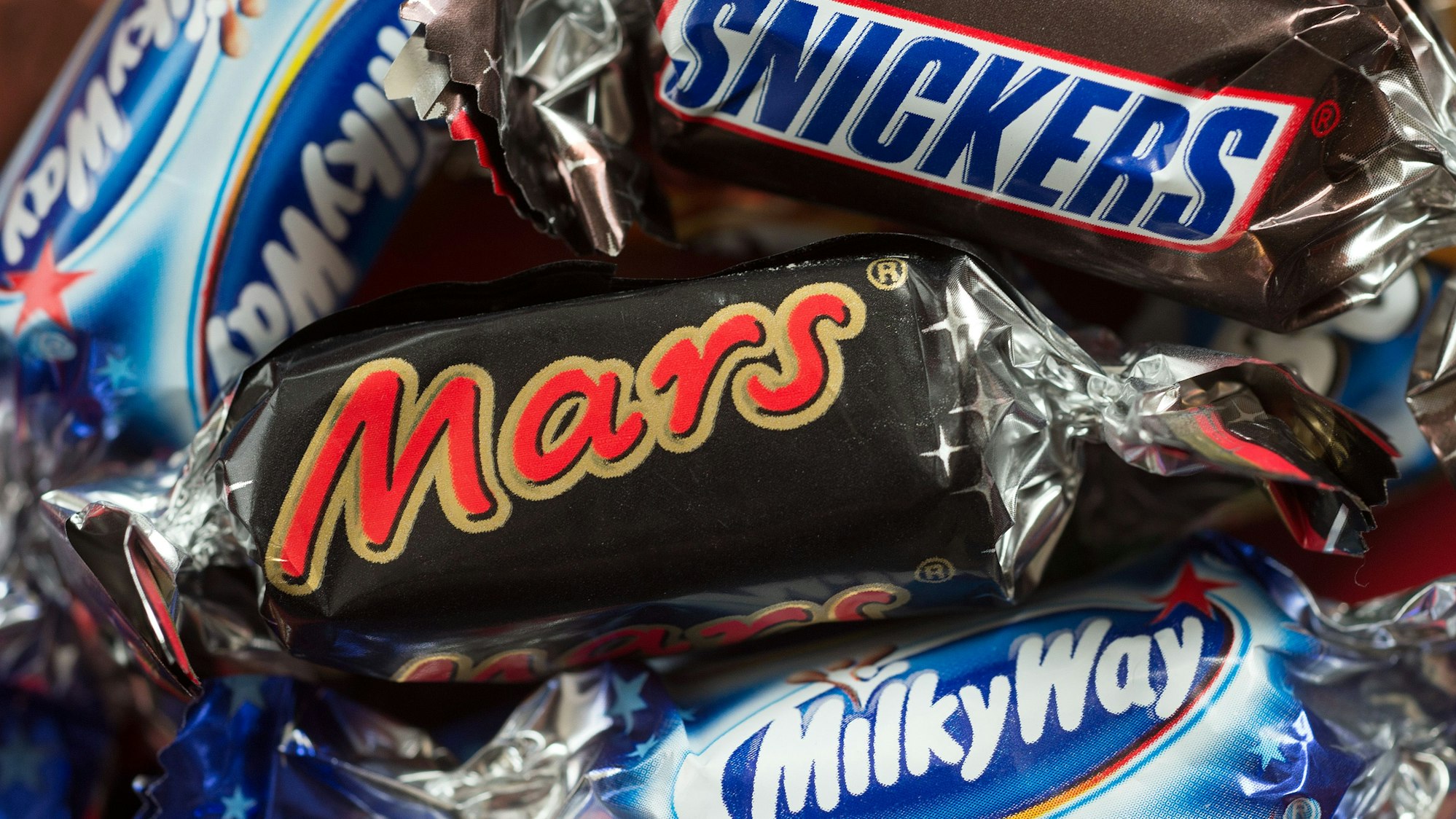 Verschiedene Mars-Schokoriegel liegen auf einem Tisch. Die Supermarkt-Kette Edeka will die Produkte des US-Herstellers aus seinem Sortiment streichen.