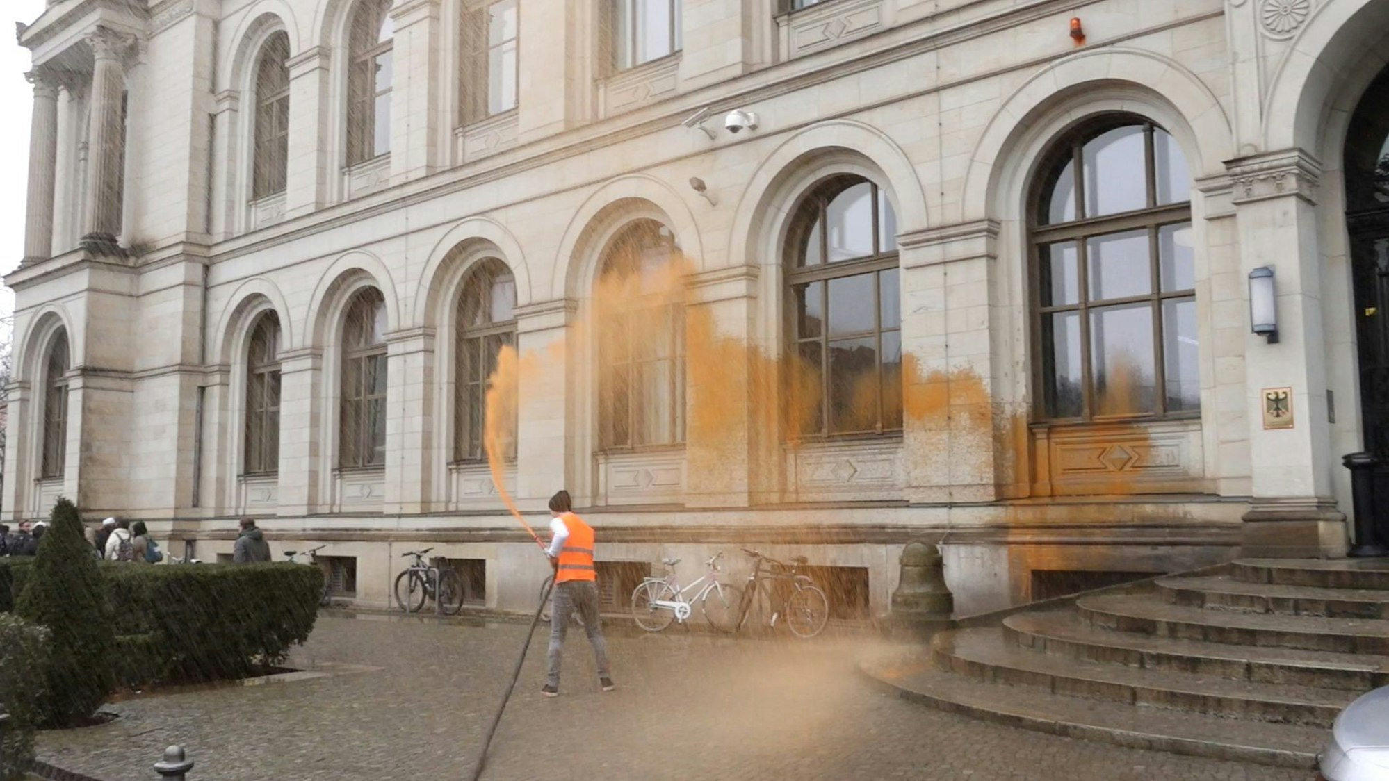 Ein Aktivist bespritzt das Bundesverkehrsministerium.