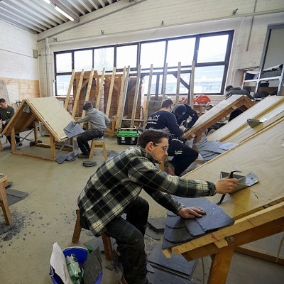 Dachdeckerlehrlinge im dritten Lehrjahr lernen den Umgang mit Schiefer.