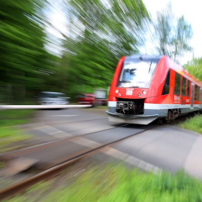 Die Regionalbahn 25 an einem Bahnübergang.