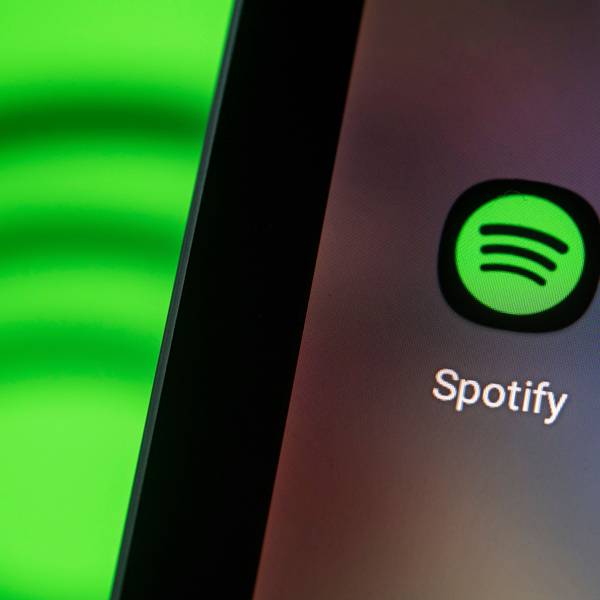 Auf dem Bildschirm eines Smartphones sieht man das Logo der App von Spotify.