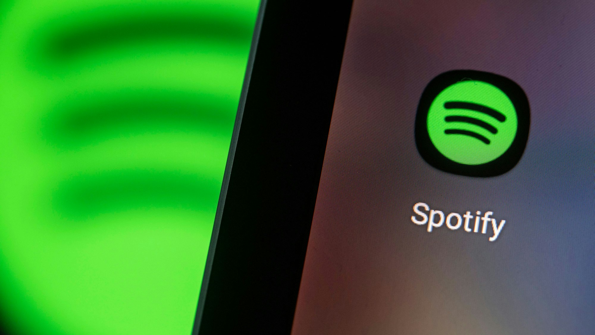 Auf dem Bildschirm eines Smartphones sieht man das Logo der App von Spotify.