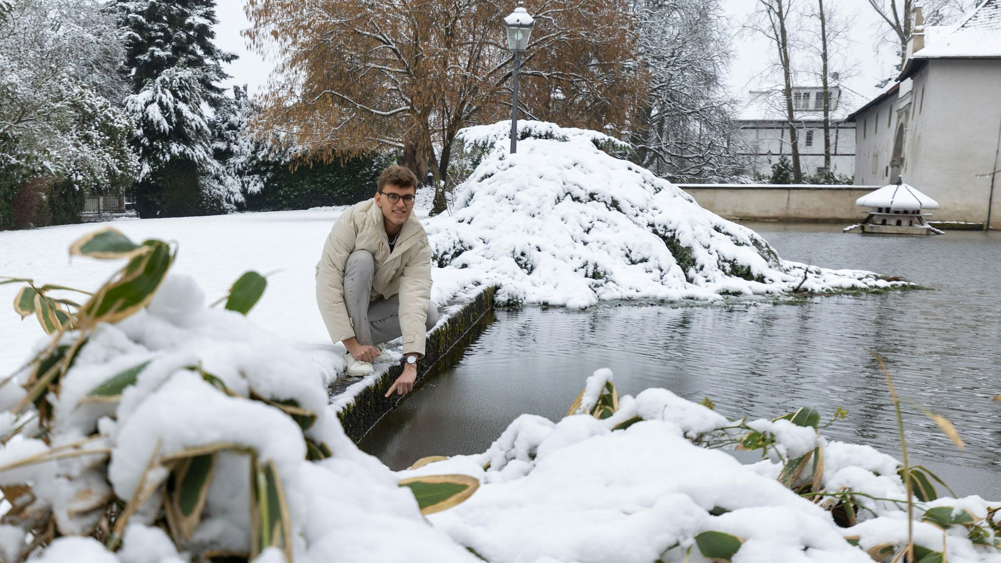 Benjamin Vieten zeigt, wo der Wassergraben von Burg Odenhausen in Wachtberg-Berkum bei Starkregen überläuft und wie viel Wasser nötig ist, damit die Burg sicher stehen bleibt.
