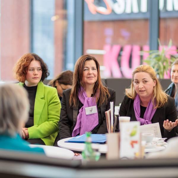 Drei Frauen sitzen bei einer Informationsveranstaltung nebeneinander.