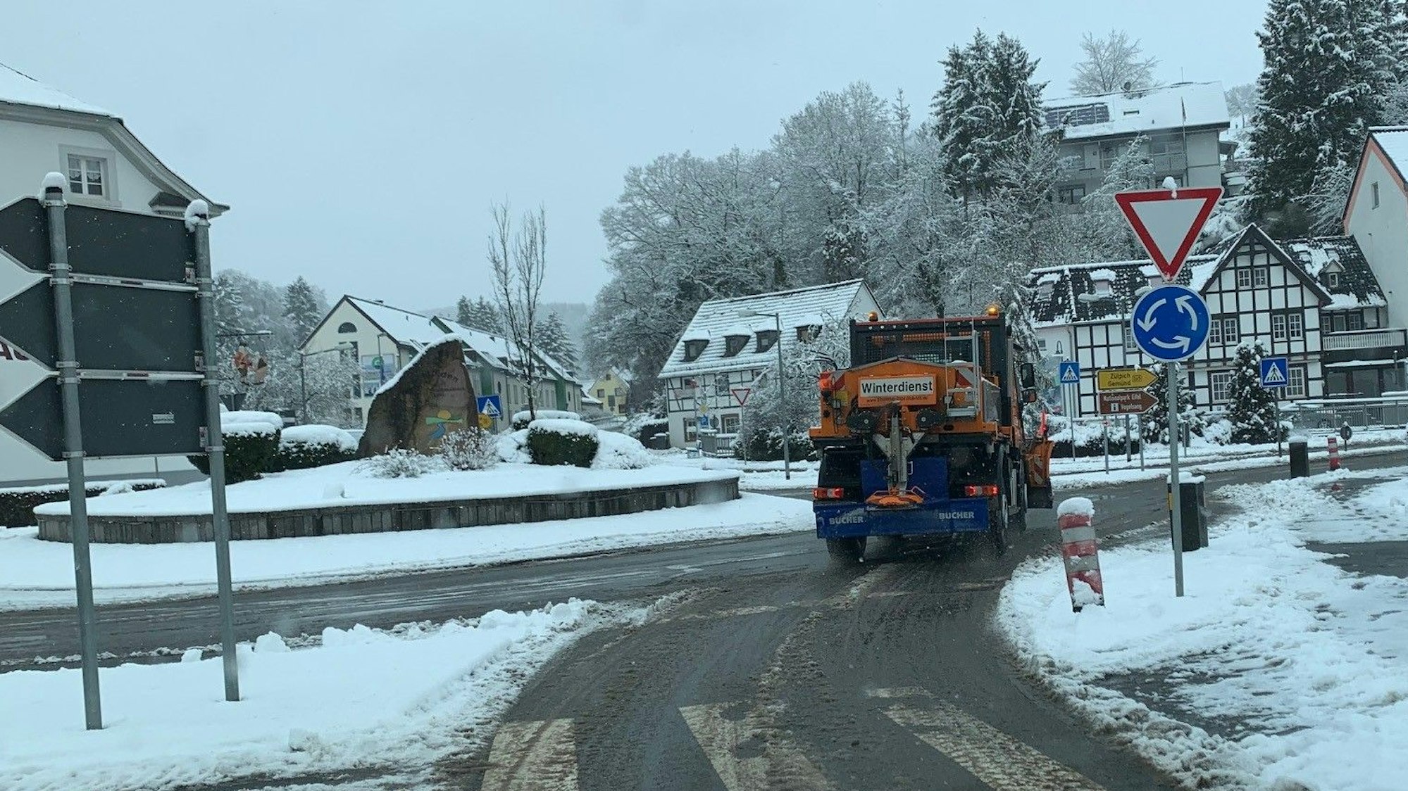 Ein Räumfahrzeug fährt in der Eifel durch einen Kreisverkehr.