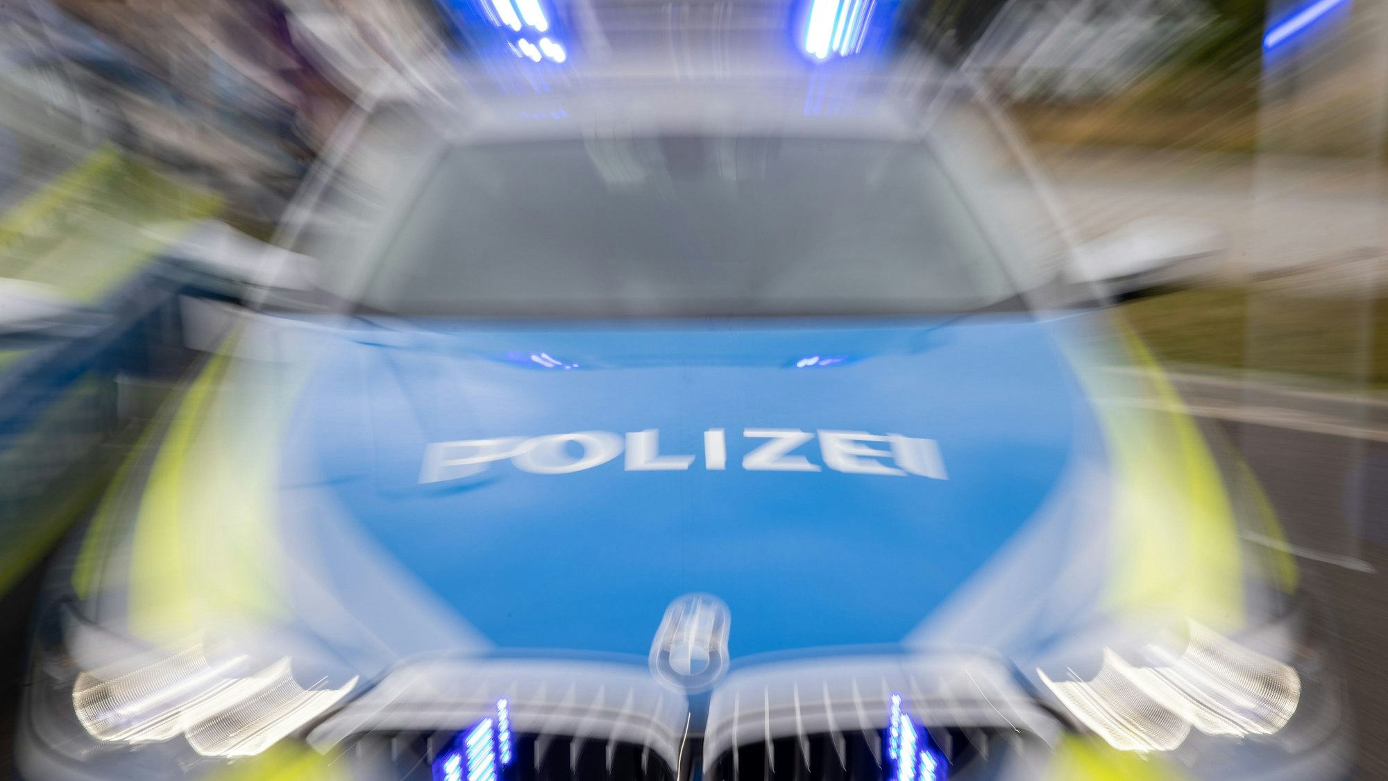 An einem Polizeifahrzeug blinkt ein Blaulicht.